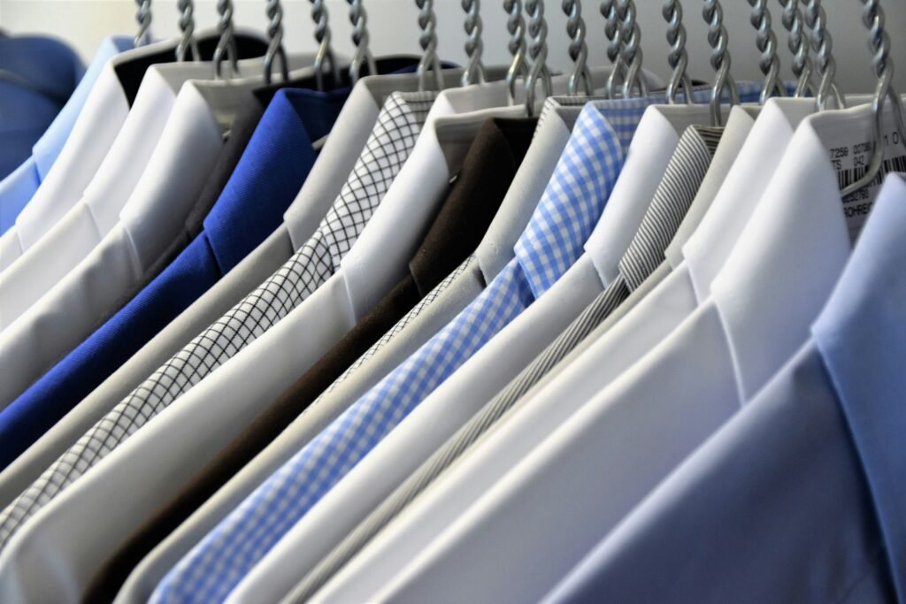 Assorted colorful dress shirts hanging neatly on a rack, featuring various patterns and styles.